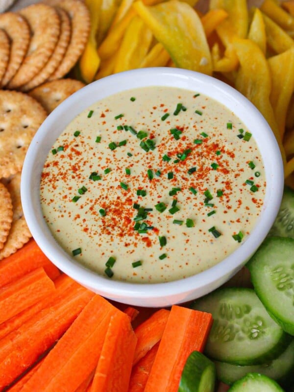 Cottage cheese deviled egg dip in a white bowl with veggies and crackers.