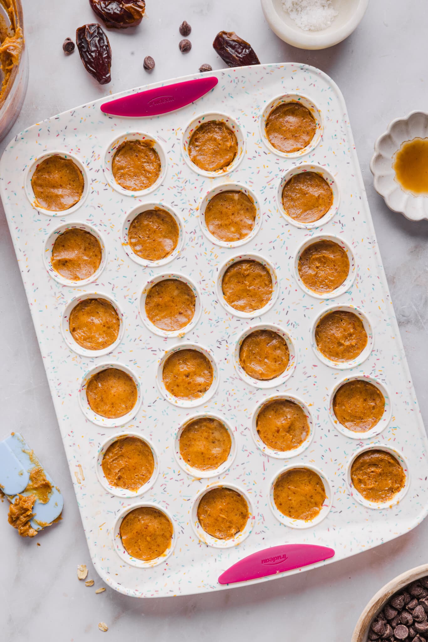 Date caramel layered with chocolate in a mini muffin silicone pan.