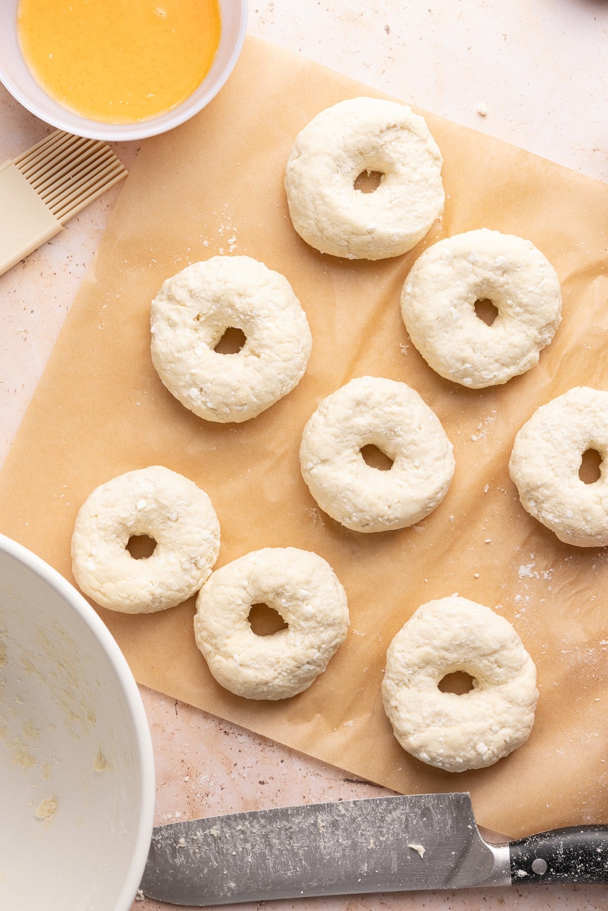 Cottage cheese bagel dough formed in a bagel shape on parchment paper.
