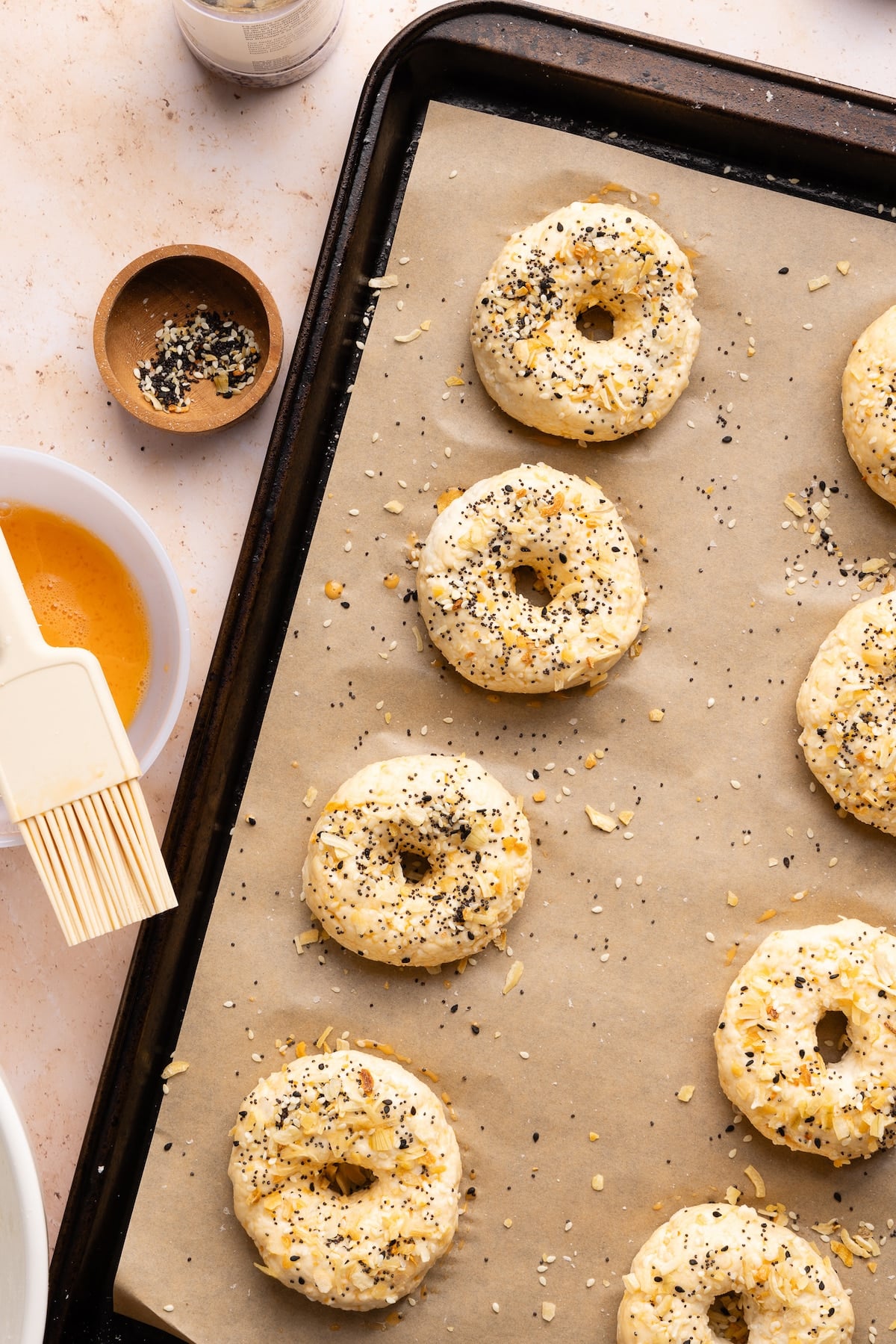 Cottage cheese bagels being seasoned with everything bagel seasoning.