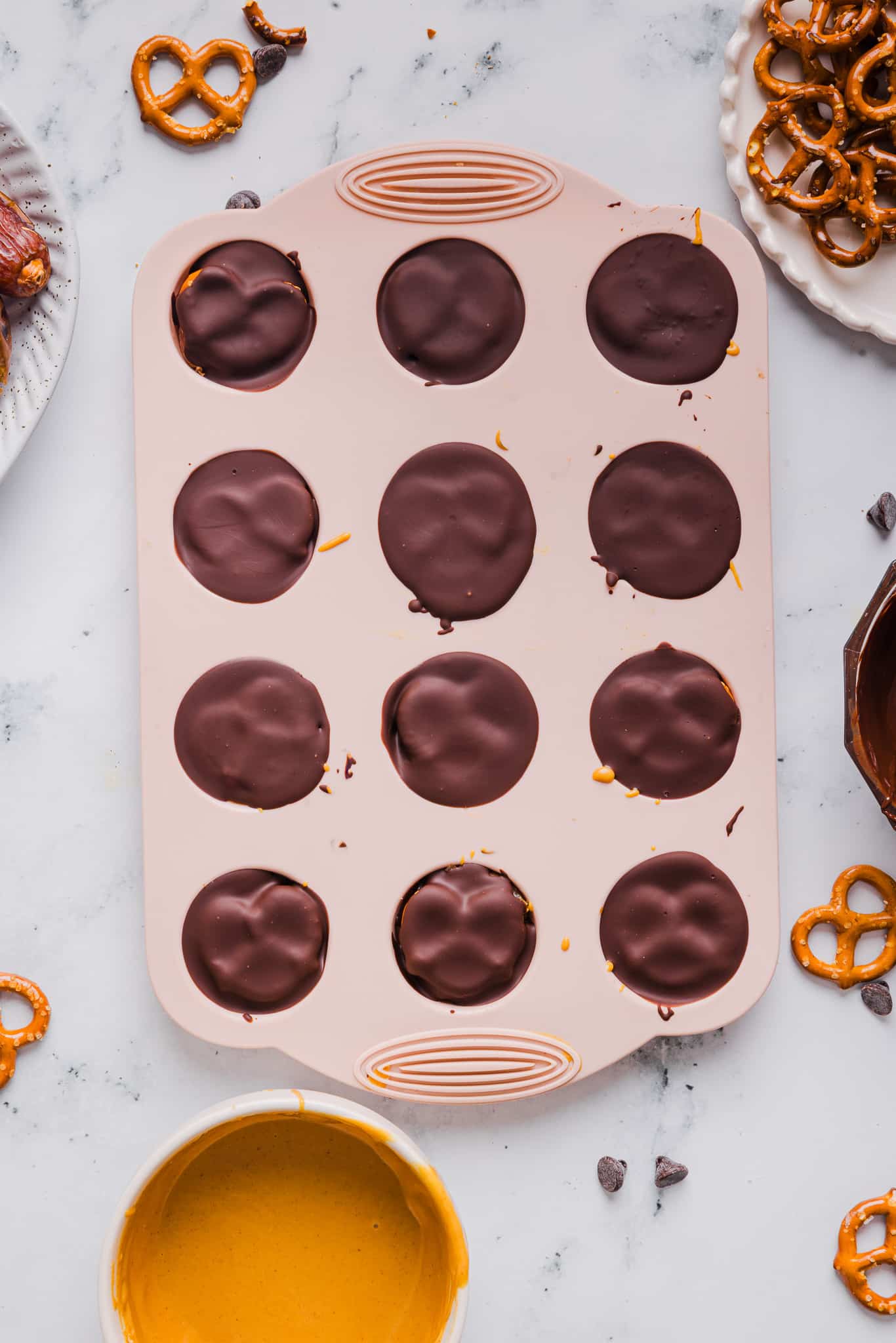 Chocolate pretzel peanut butter date bites in a silicone mold.