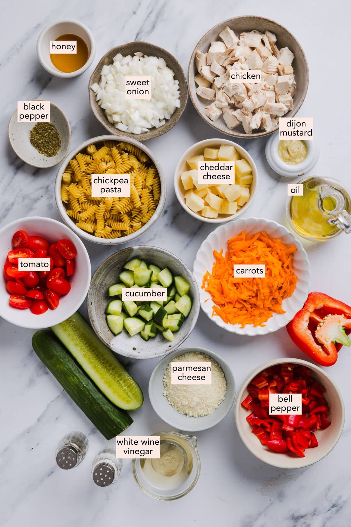 High protein pasta salad ingredients on a countertop with labels.
