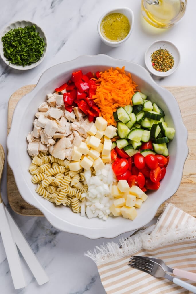 Ingredients for high protein pasta salad in a large bowl.