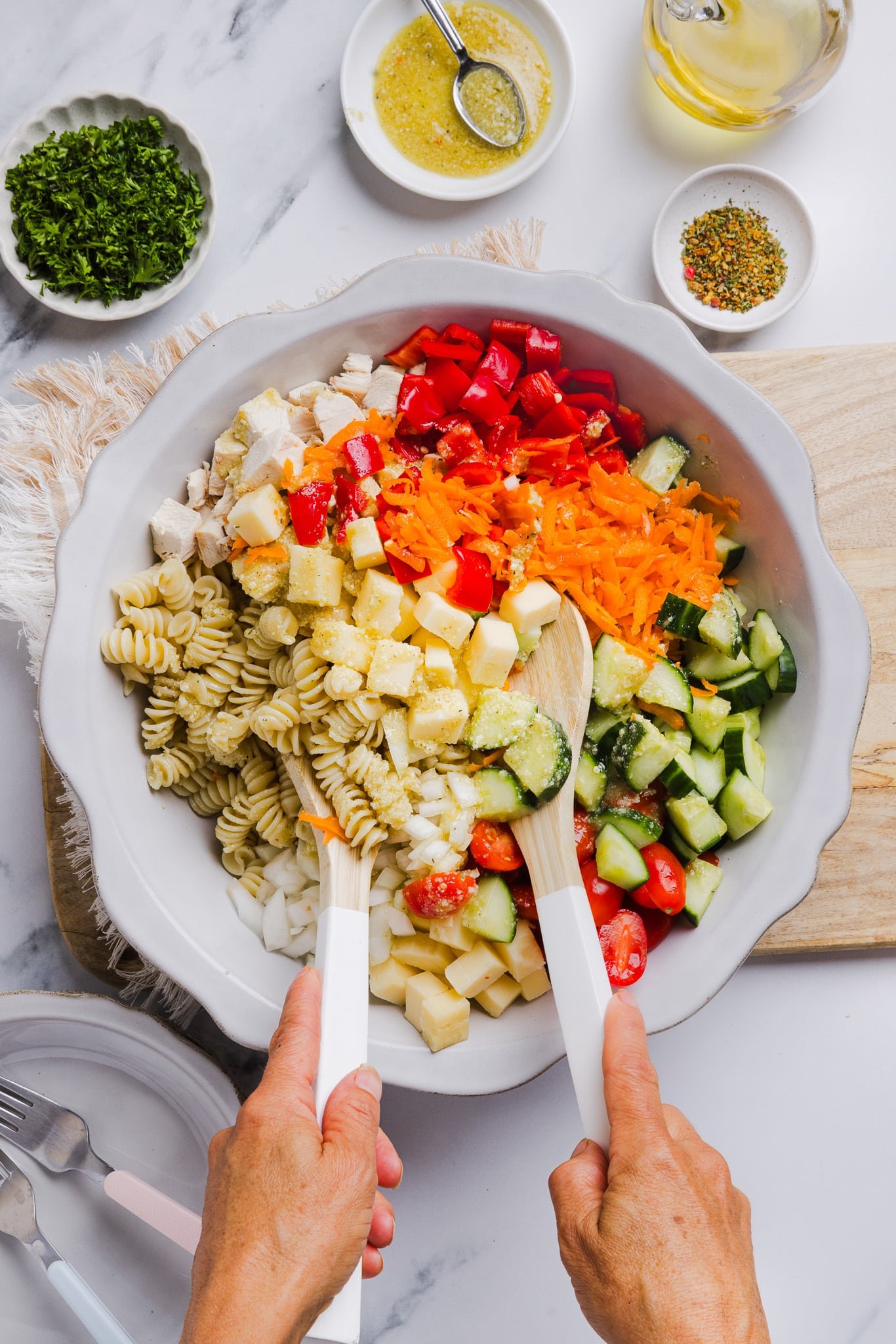 High protein pasta salad being mixed up in a large bowl.