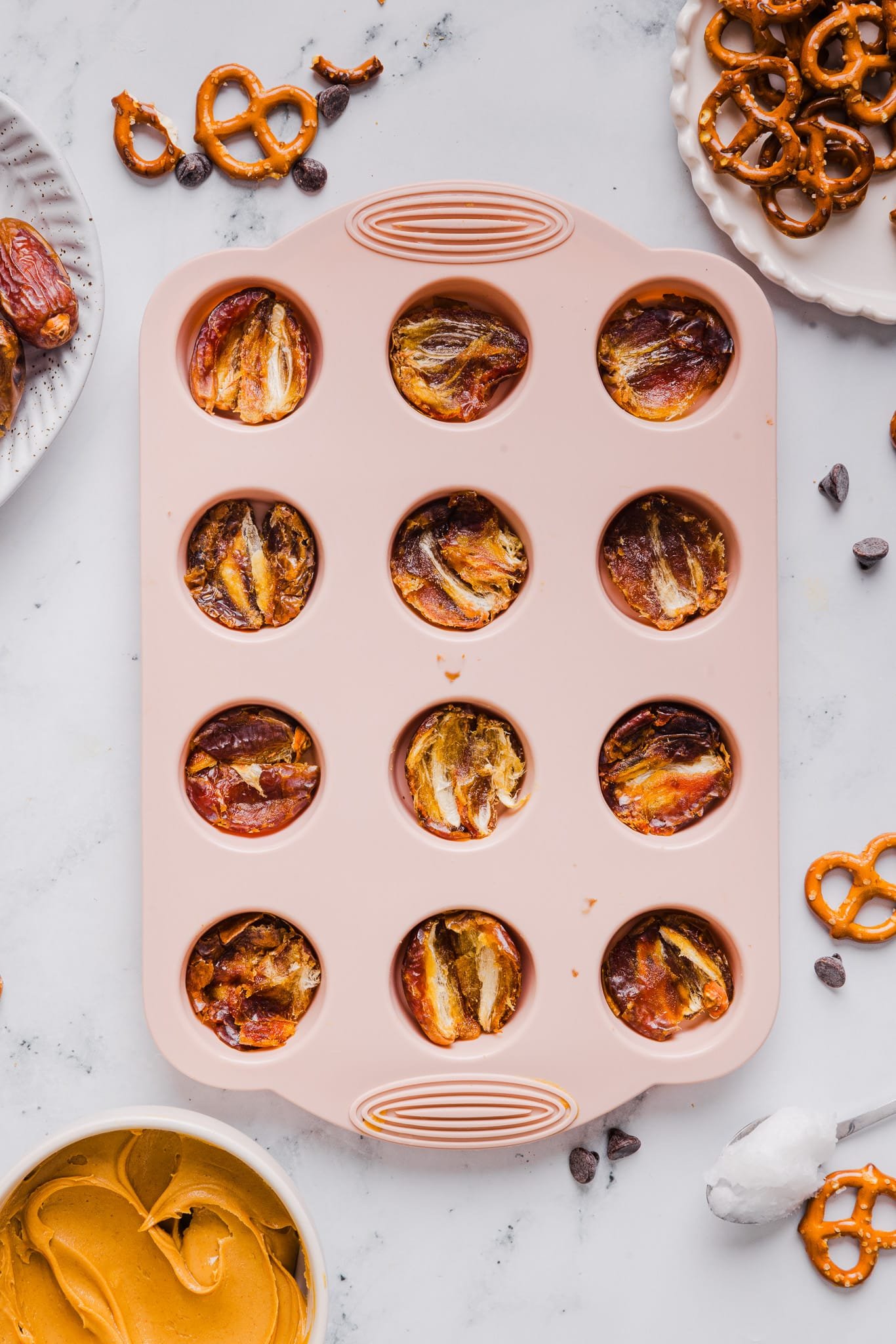 Dates being pressed into a mini silicone muffin pan.
