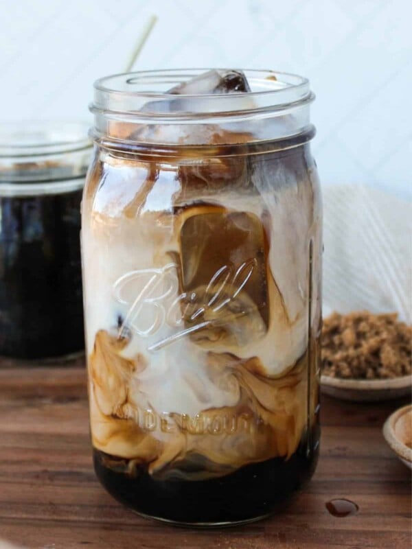 Iced brown sugar coffee and milk swirled in a large mason jar.