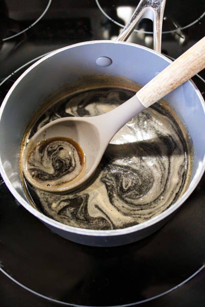 A pan on the stove simmering brown sugar simple syrup.