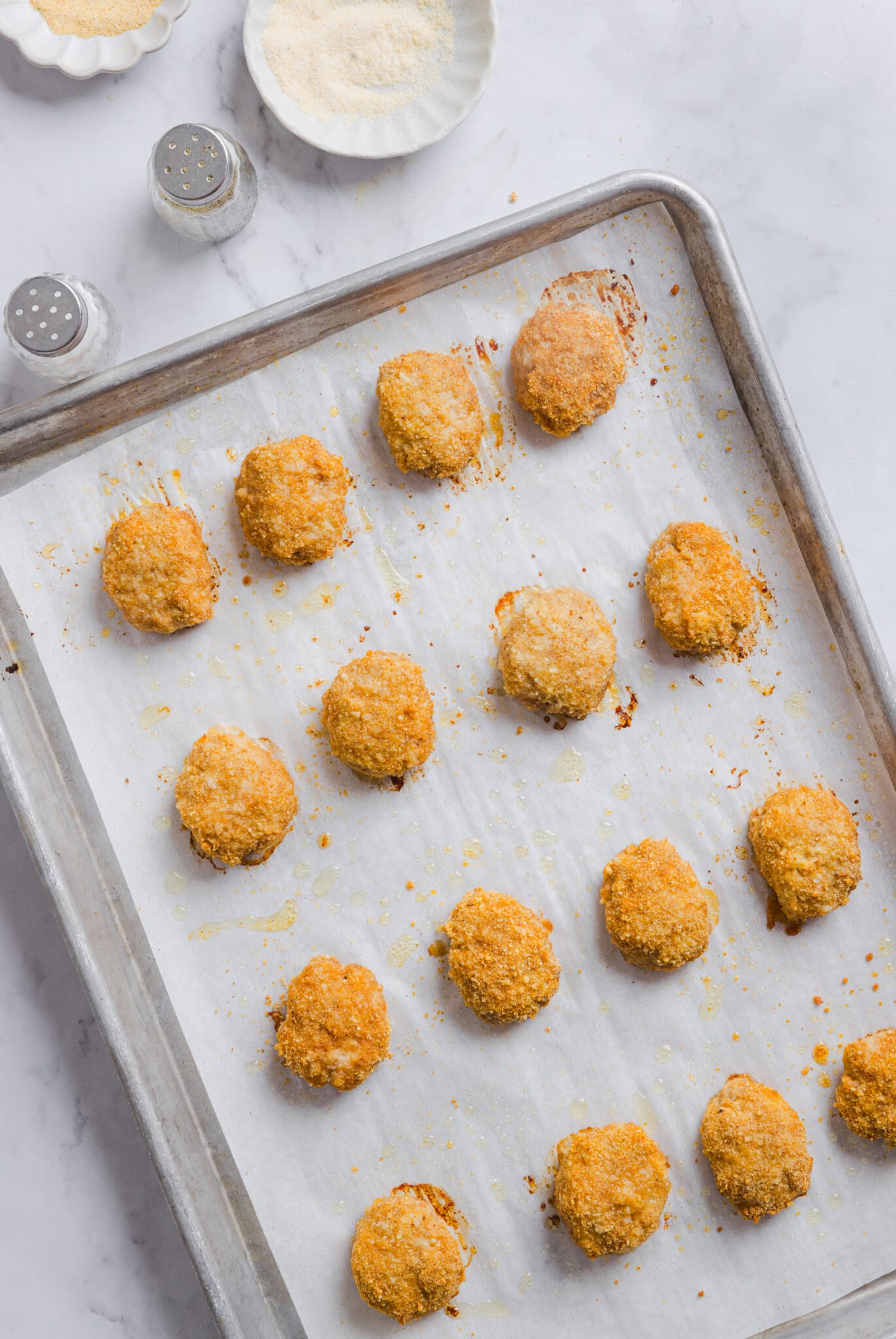Baked ground chicken nuggets on a sheet pan.