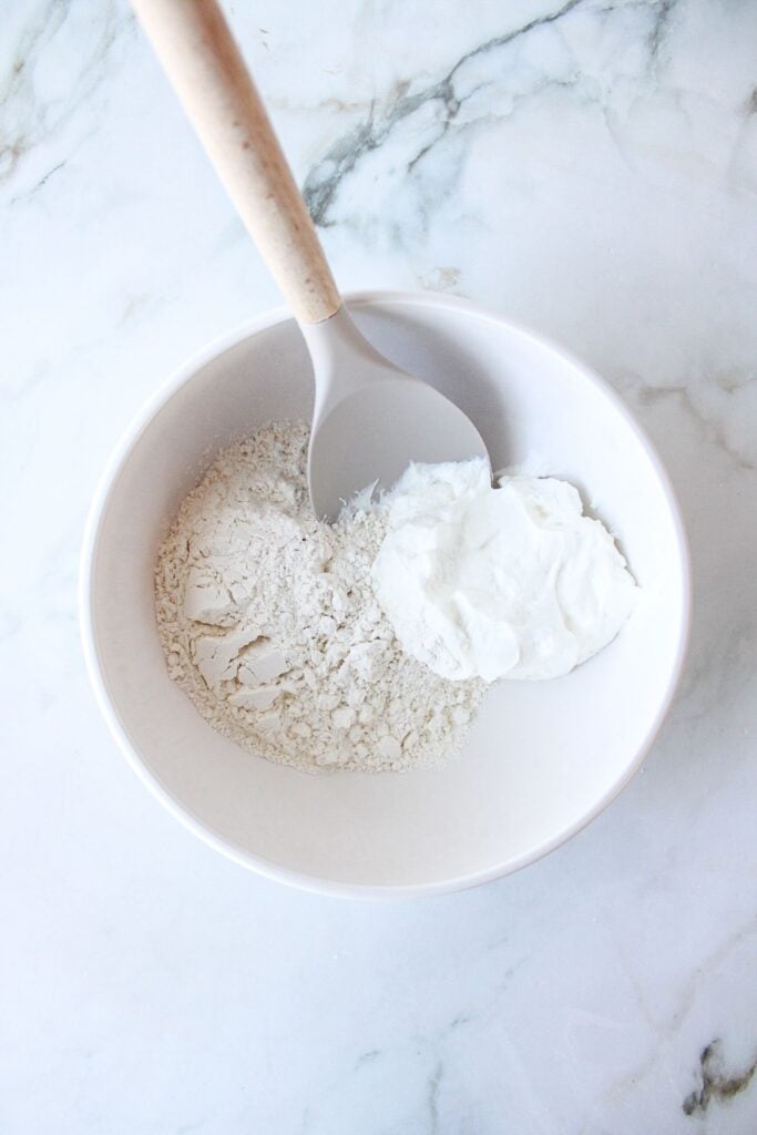 Greek yogurt and self-rising flour in a bowl, not yet mixed.
