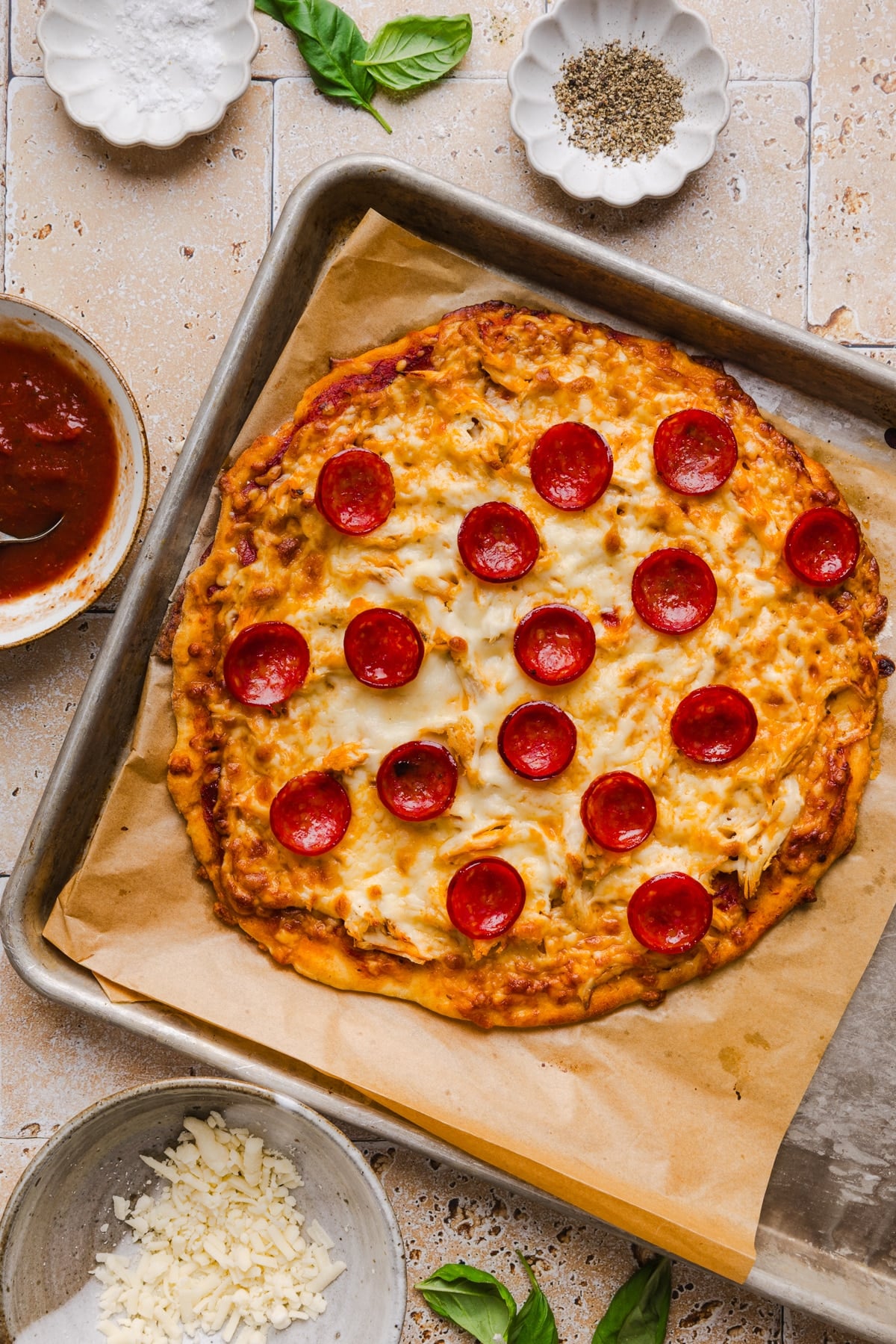 The baked high protein pizza on the piece of brown parchment paper after coming out of the oven.