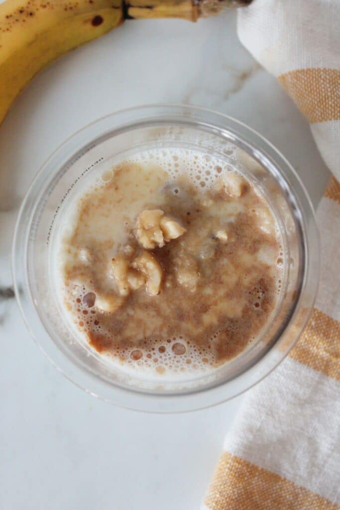 An overhead shot of Ninja cream banana ice cream ingredients in a pint container before being blended.