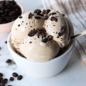 Ninja creami coffee ice cream in a white bowl with chocolate chunks.