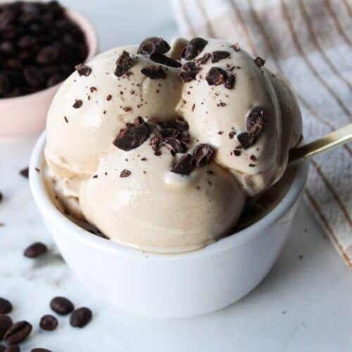 Ninja creami coffee ice cream in a white bowl with chocolate chunks.