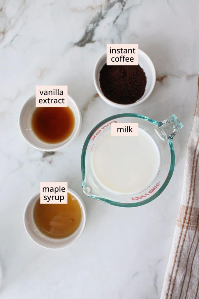 Milk, maple syrup, vanilla extract and instant coffee in containers with labels.