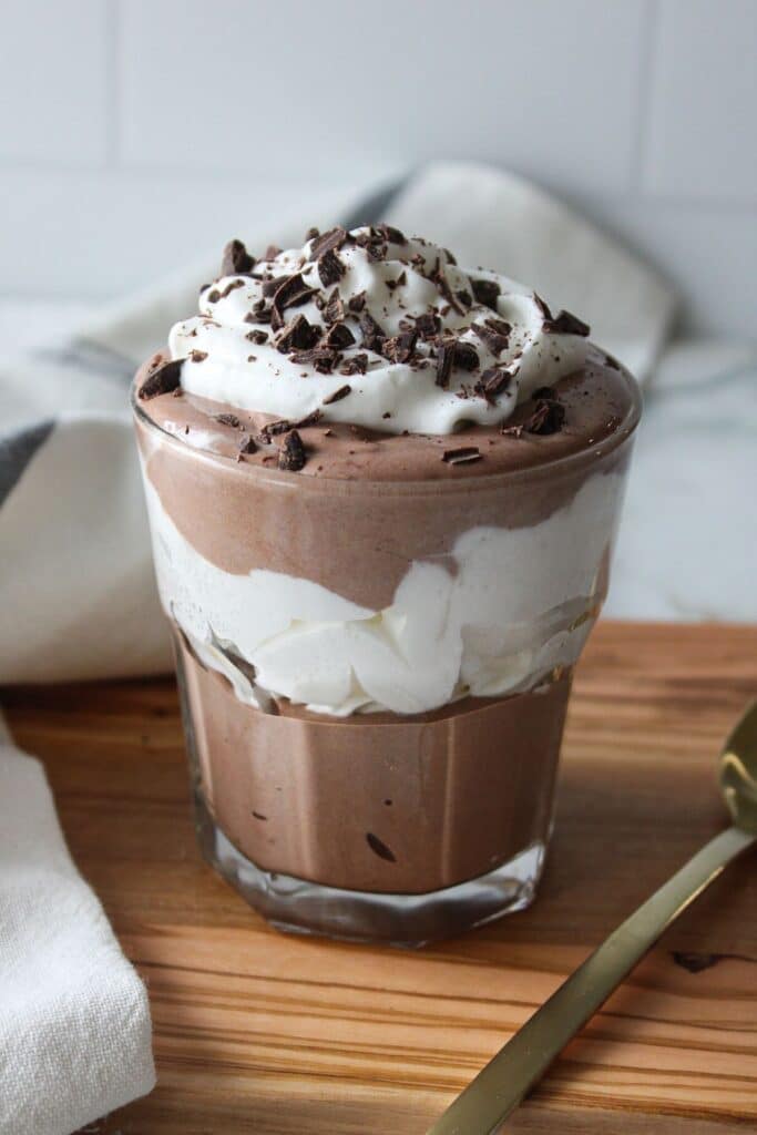 Cottage cheese chocolate mousse layered with whipped cream in a glass.