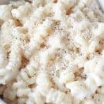 A bowl full of cottage cheese pasta sauce on chickpea pasta and topped with parmesan cheese and black pepper.