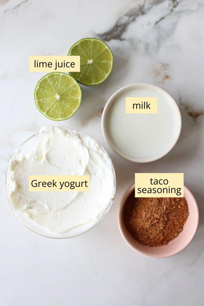 Greek yogurt taco sauce ingredients on a countertop with labels.