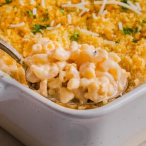 High protein Mac and cheese being scooped out of a baking dish.