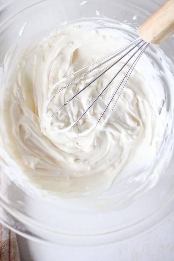 Whipped cheesecake fluff in a bowl in a whisk.