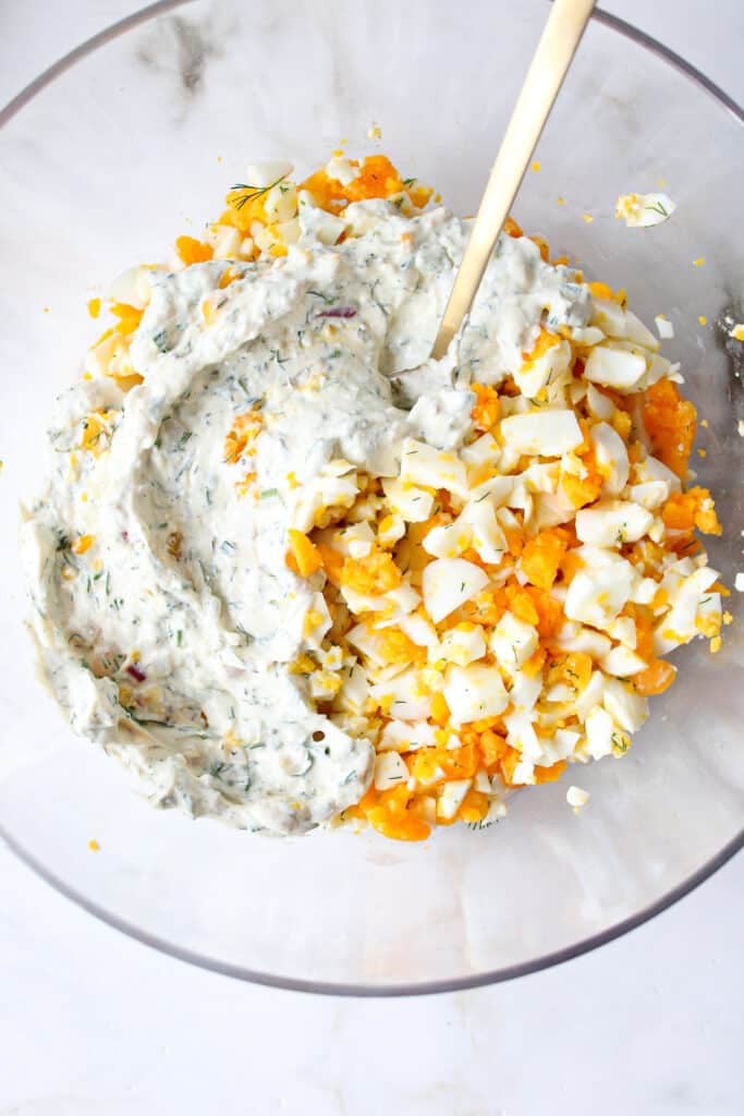 Chopped hard boiled eggs and cottage cheese egg salad dressing in a bowl.