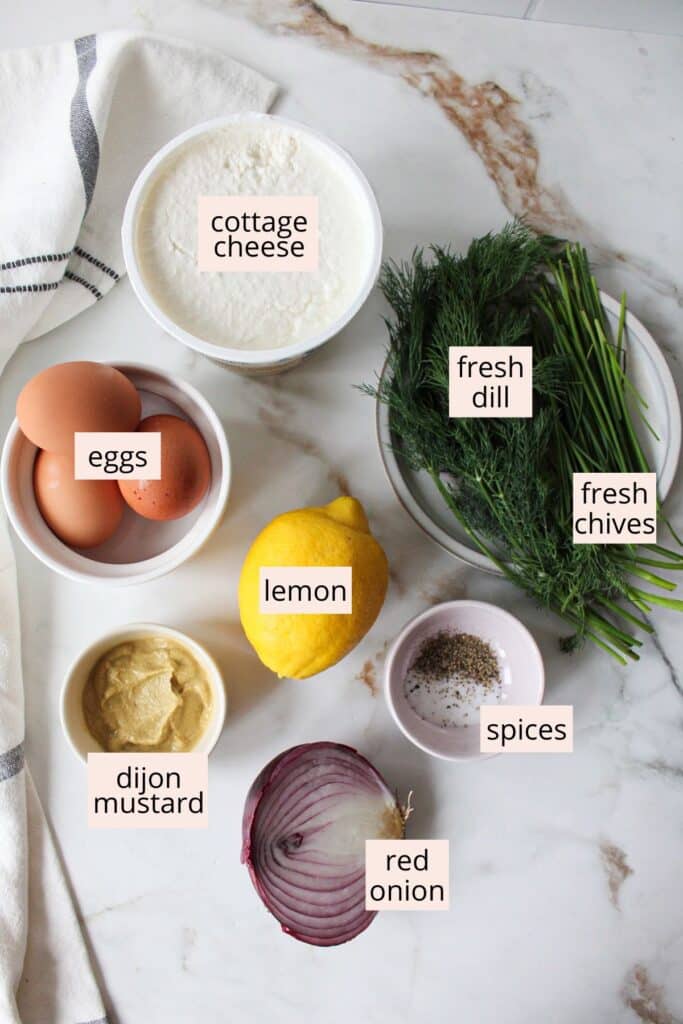 Ingredients for cottage cheese egg salad on a countertop with labels.