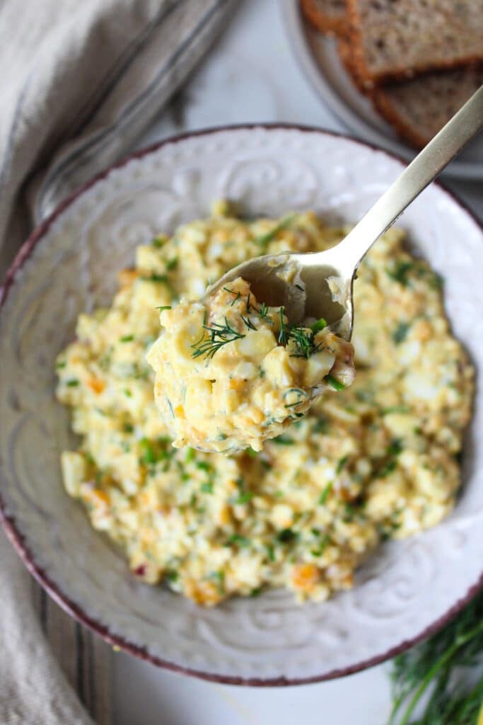 An overhead shot of a spoonful of egg salad.