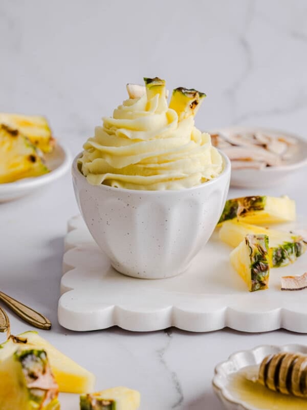 Dole whip made in the ninja creami in a white bowl on a white serving board.