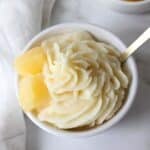 Dole whip made in the Ninja creami in a white bowl with pineapple and a spoon.