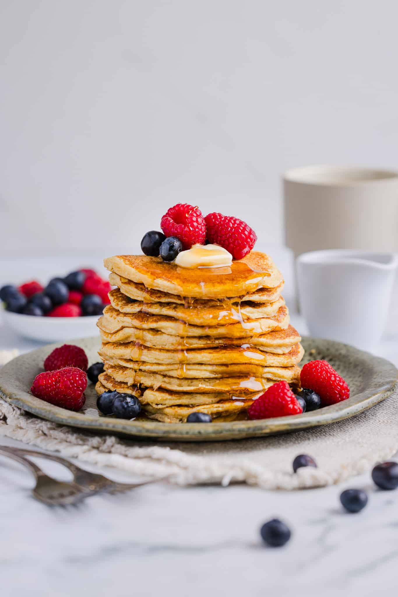 Oatmeal cottage cheese pancakes served with berries, butter and maple syrup.