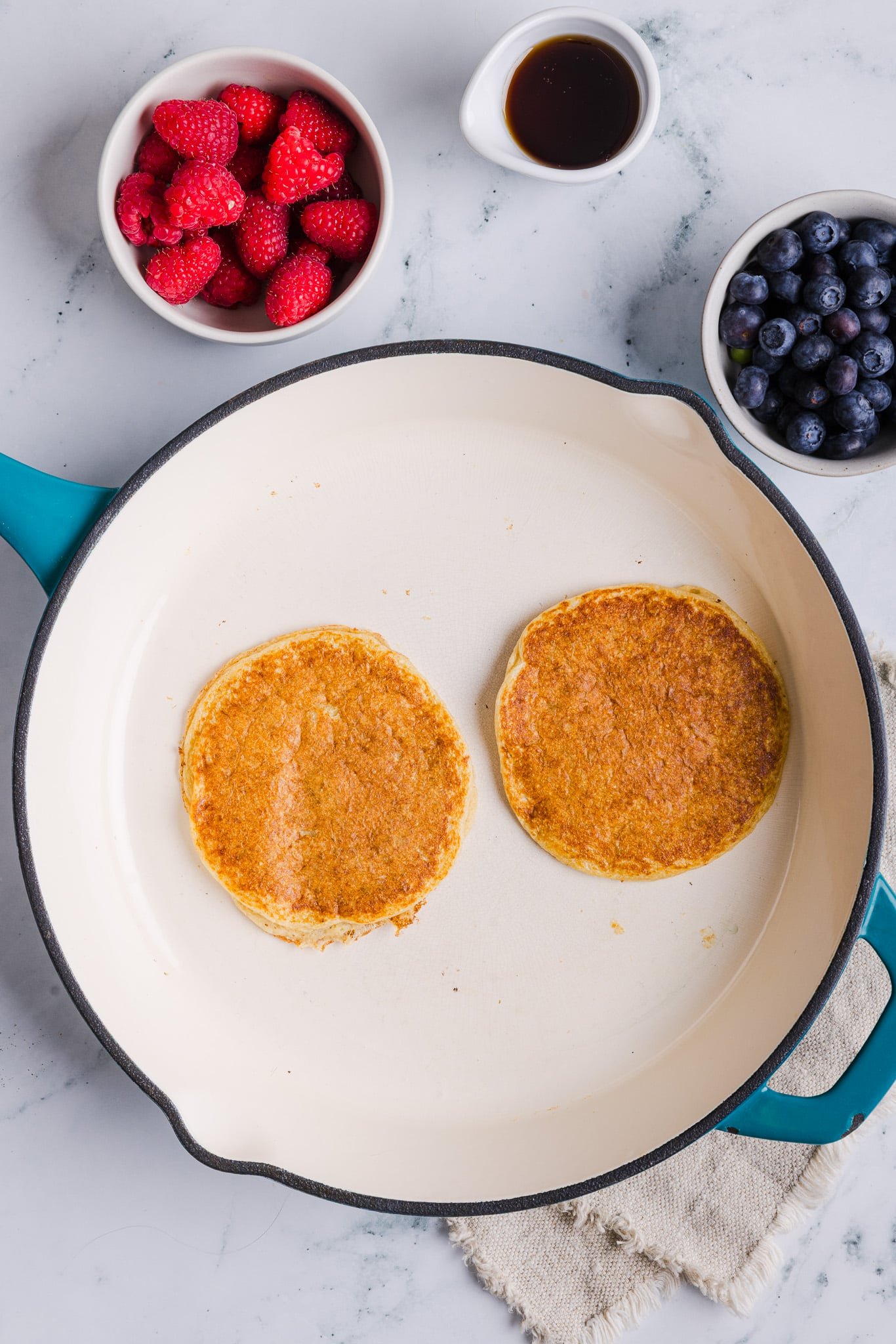 Oatmeal cottage cheese pancakes cooking in a pan.