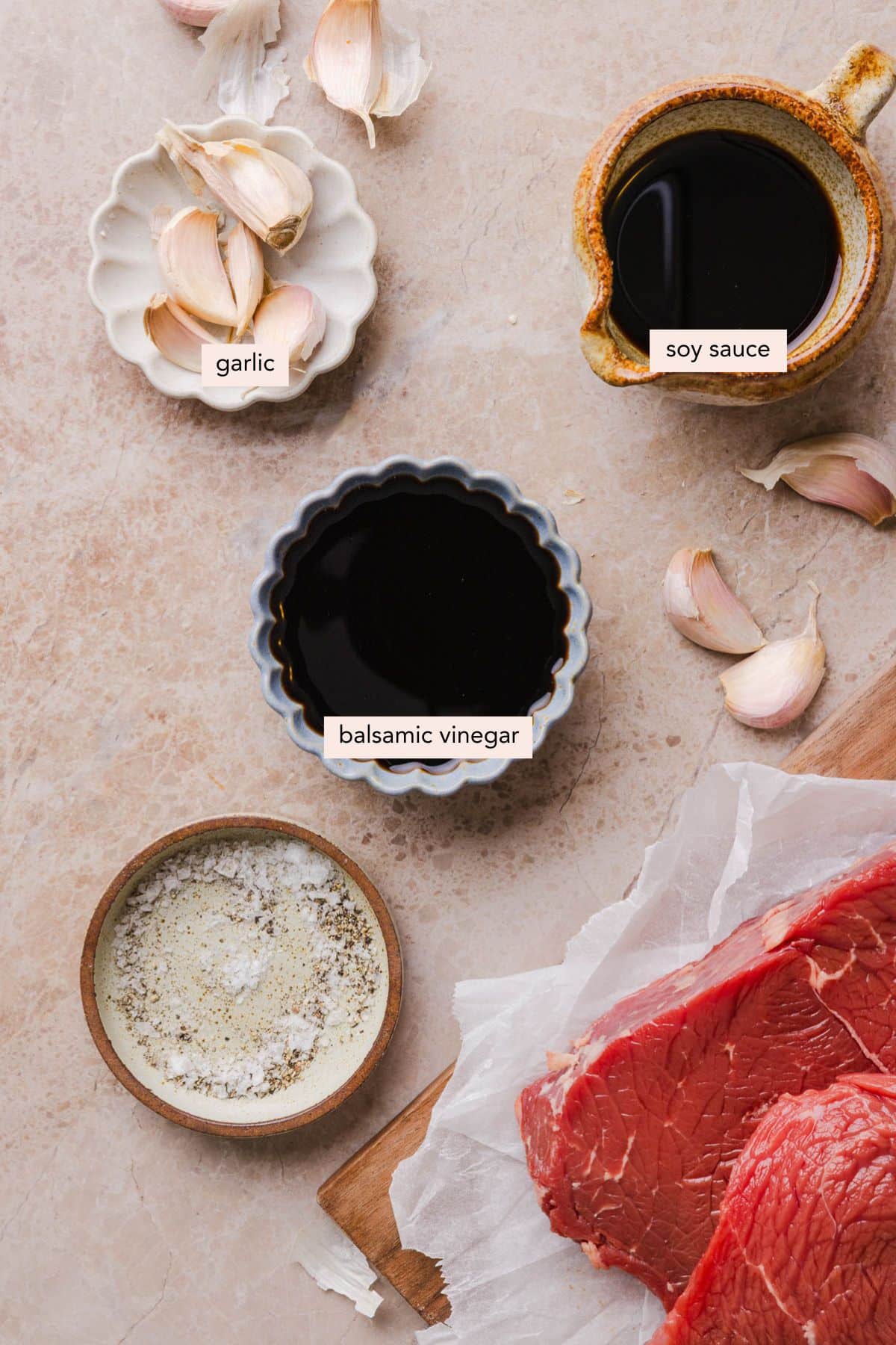 All of the ingredients for steak marinade in bowls on a countertop.
