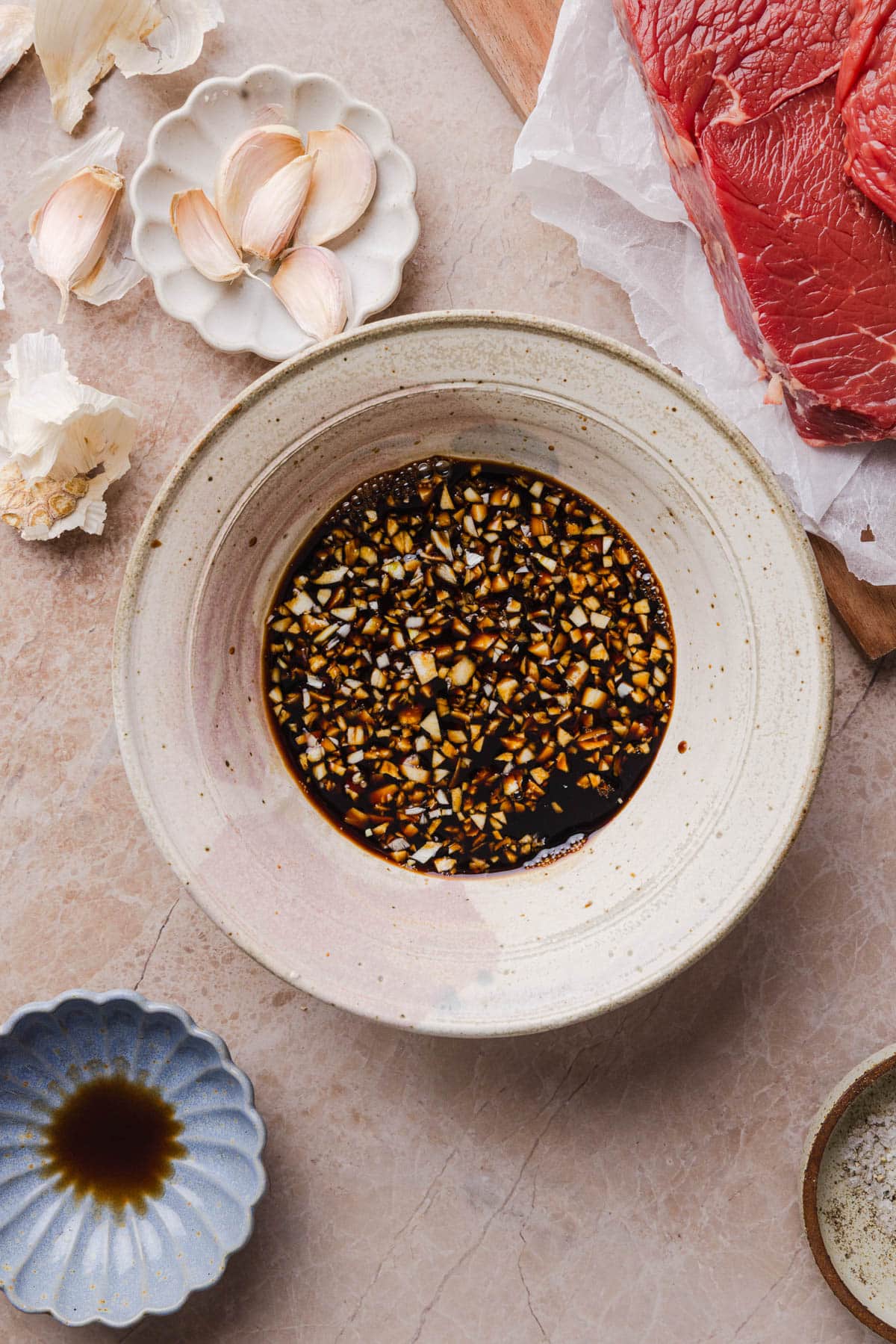 The balsamic vinegar, soy sauce, and garlic in a bowl on a countertop before mixing.