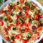 Cottage cheese taco dip topped with shredded lettuce, tomatoes and cheese.