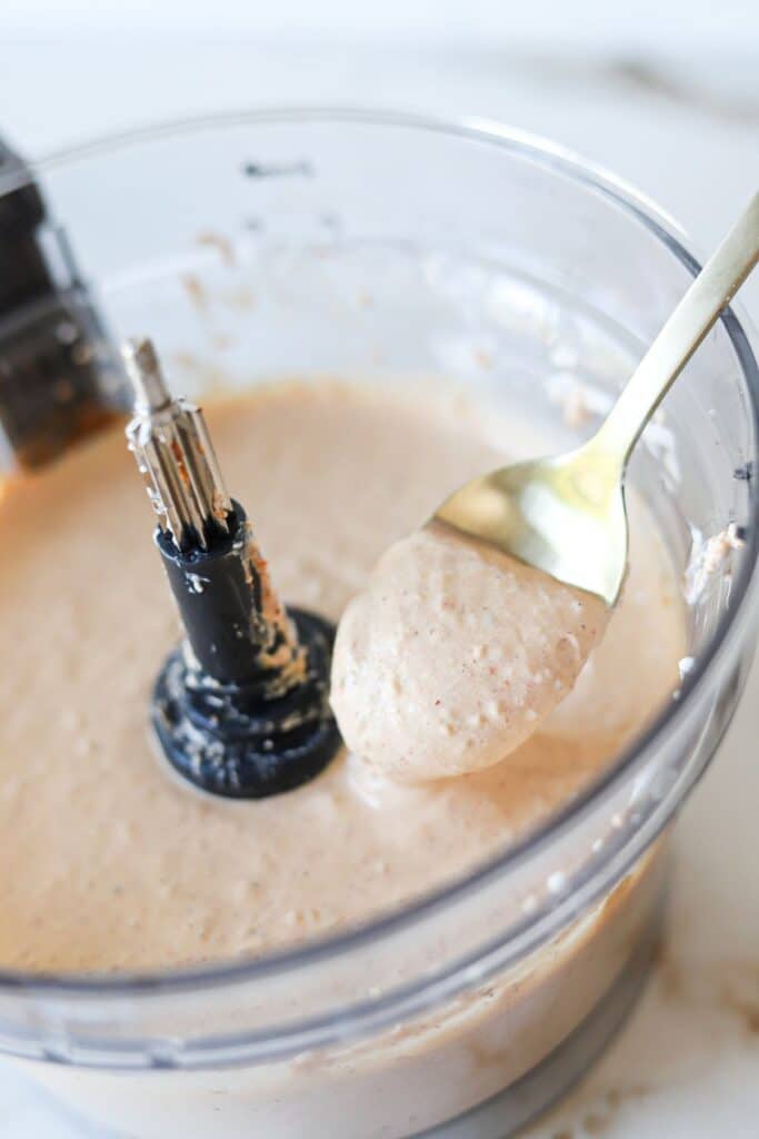 Cottage cheese taco dip blended in a food processor with a spoon.