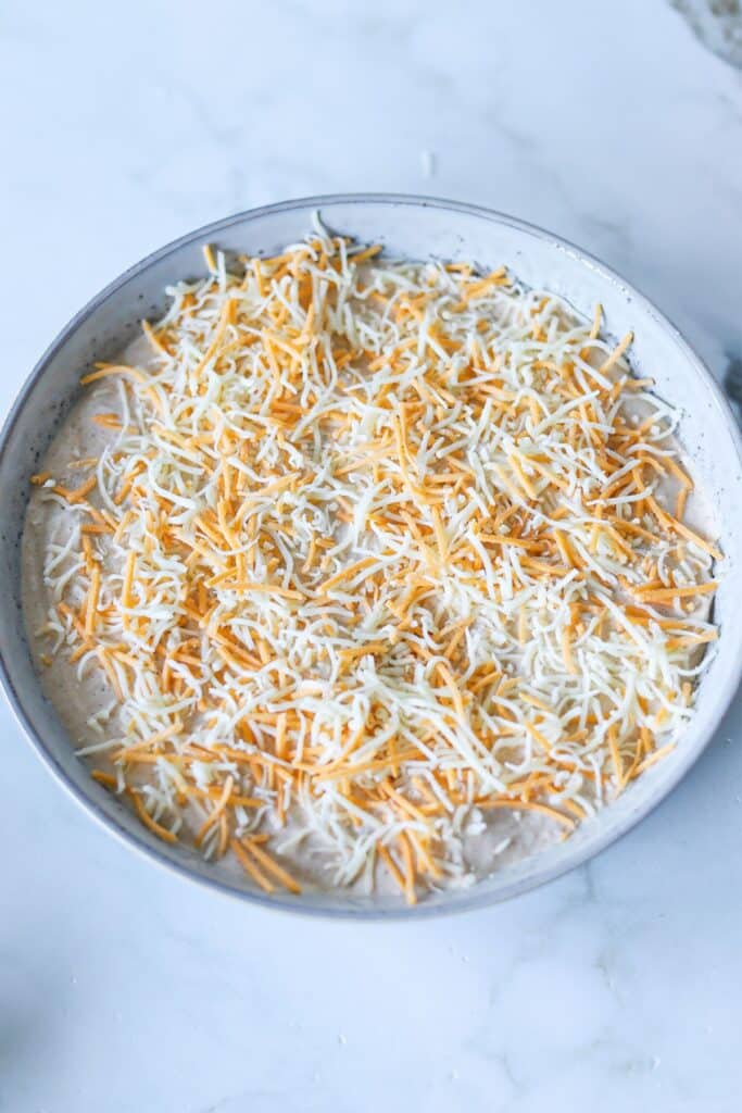 Cottage cheese taco dip in a bowl topped with shredded cheese.