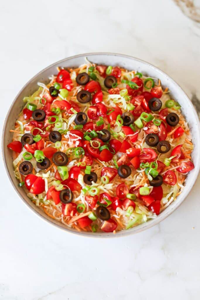 Cottage cheese taco dip topped with shredded lettuce, tomatoes and cheese.