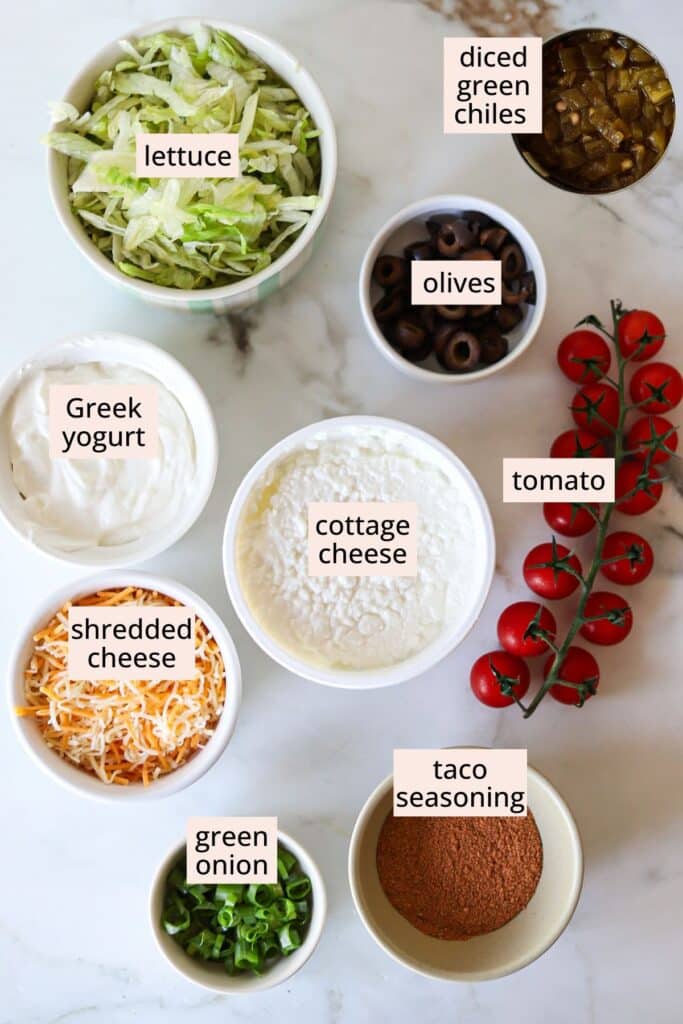 Ingredients for cottage cheese taco dip on a countertop with labels.