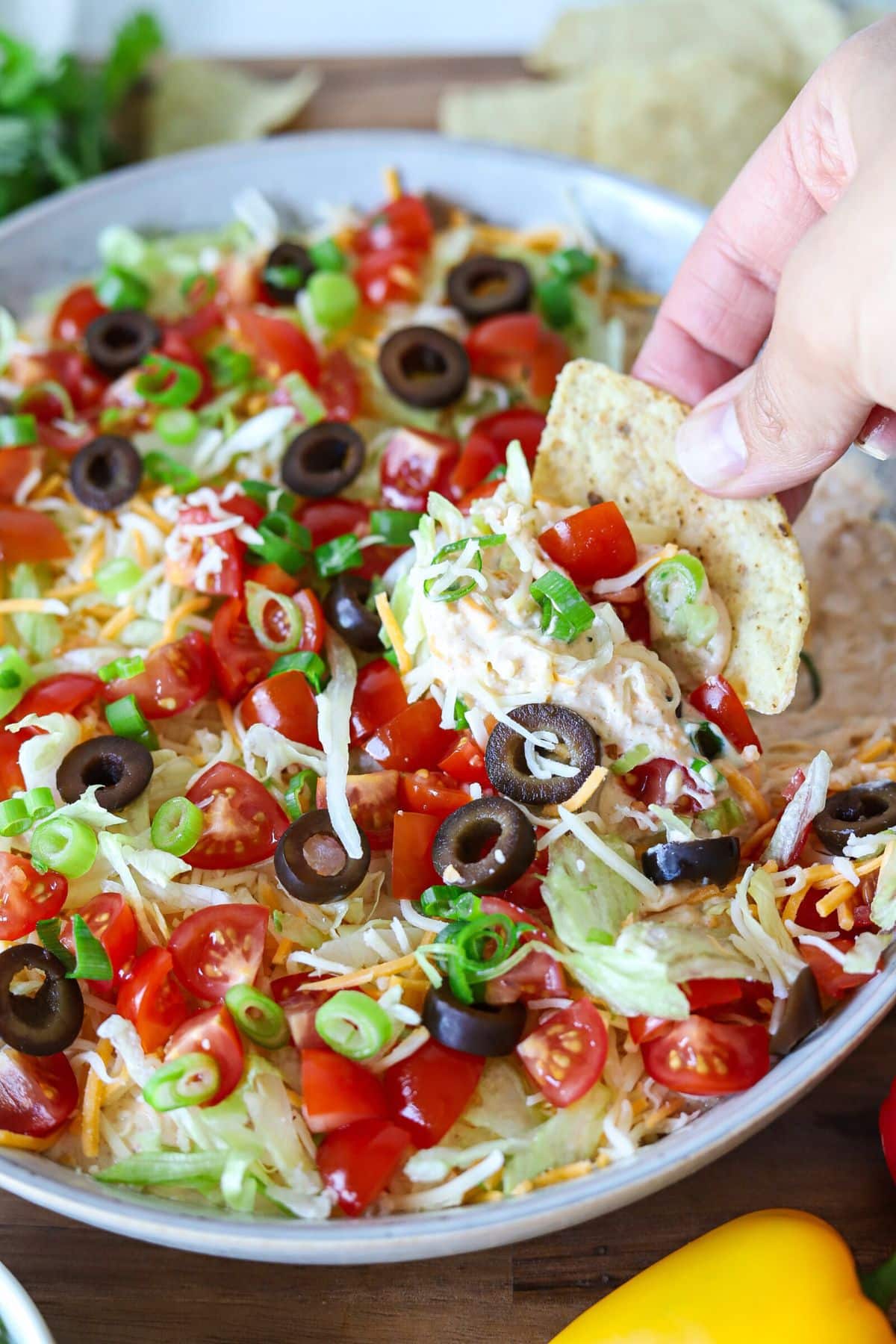A tortilla chip being dipped into cottage cheese taco dip.