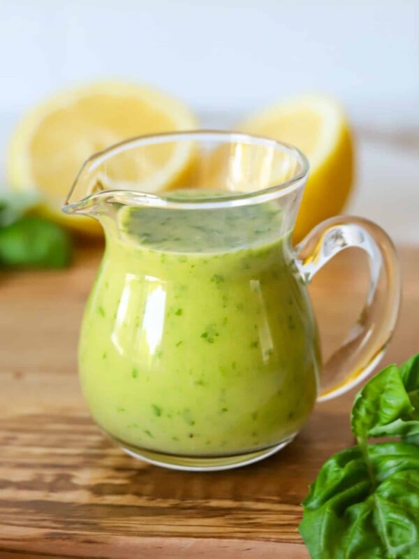 Lemon basil vinaigrette dressing in a glass dressing container.