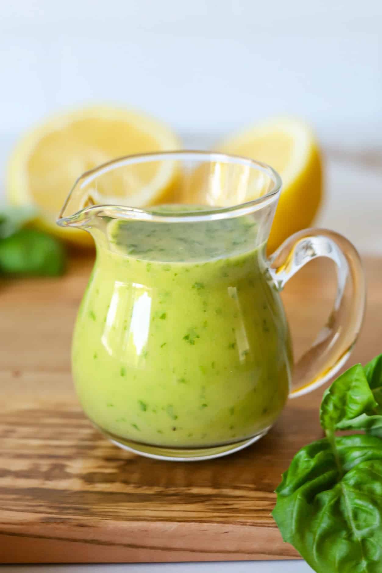 Lemon basil vinaigrette dressing in a glass dressing container.