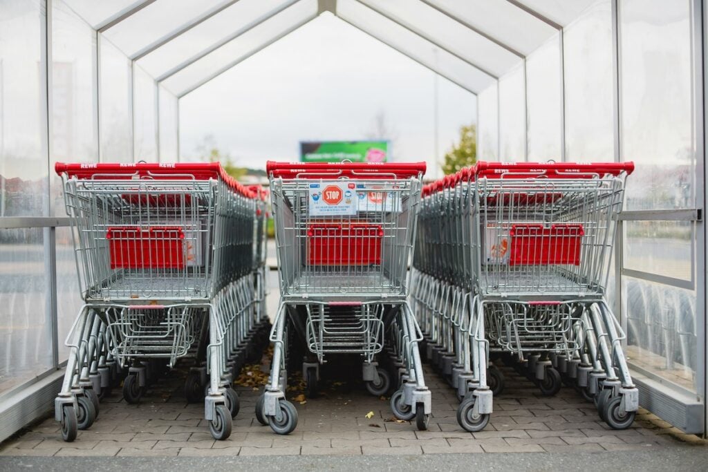 Three rows of red and silver shopping carts ready for shoppers to use. 