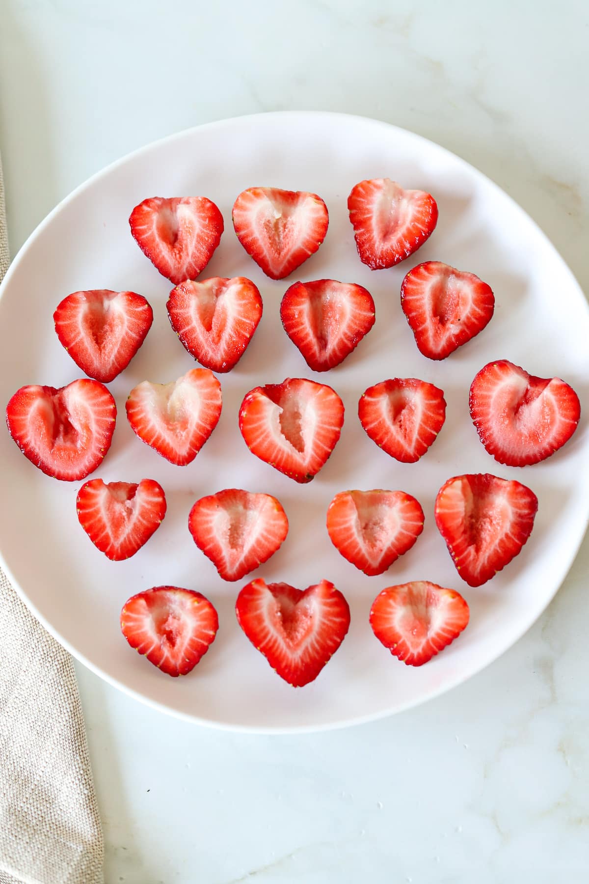 Halved strawberries on a platter.