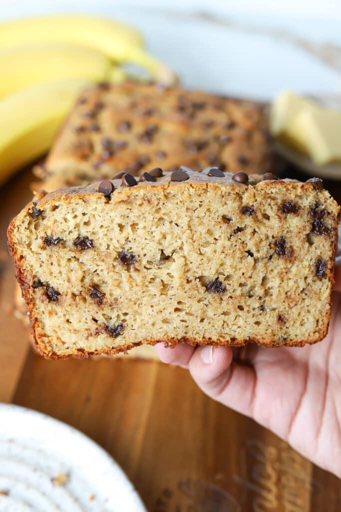 A close up shot of a held up slice of kodiak banana bread.