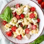 Tortellini caprese salad in a bowl garnished with extra basil.