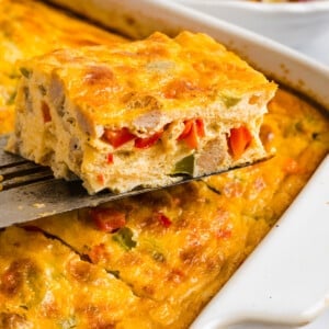 A spatula lifts a slice of cottage cheese egg bake from the casserole dish for serving.