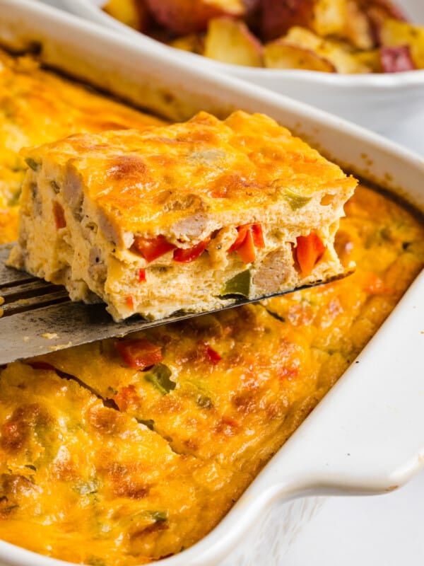 A spatula lifts a slice of cottage cheese egg bake from the casserole dish for serving.