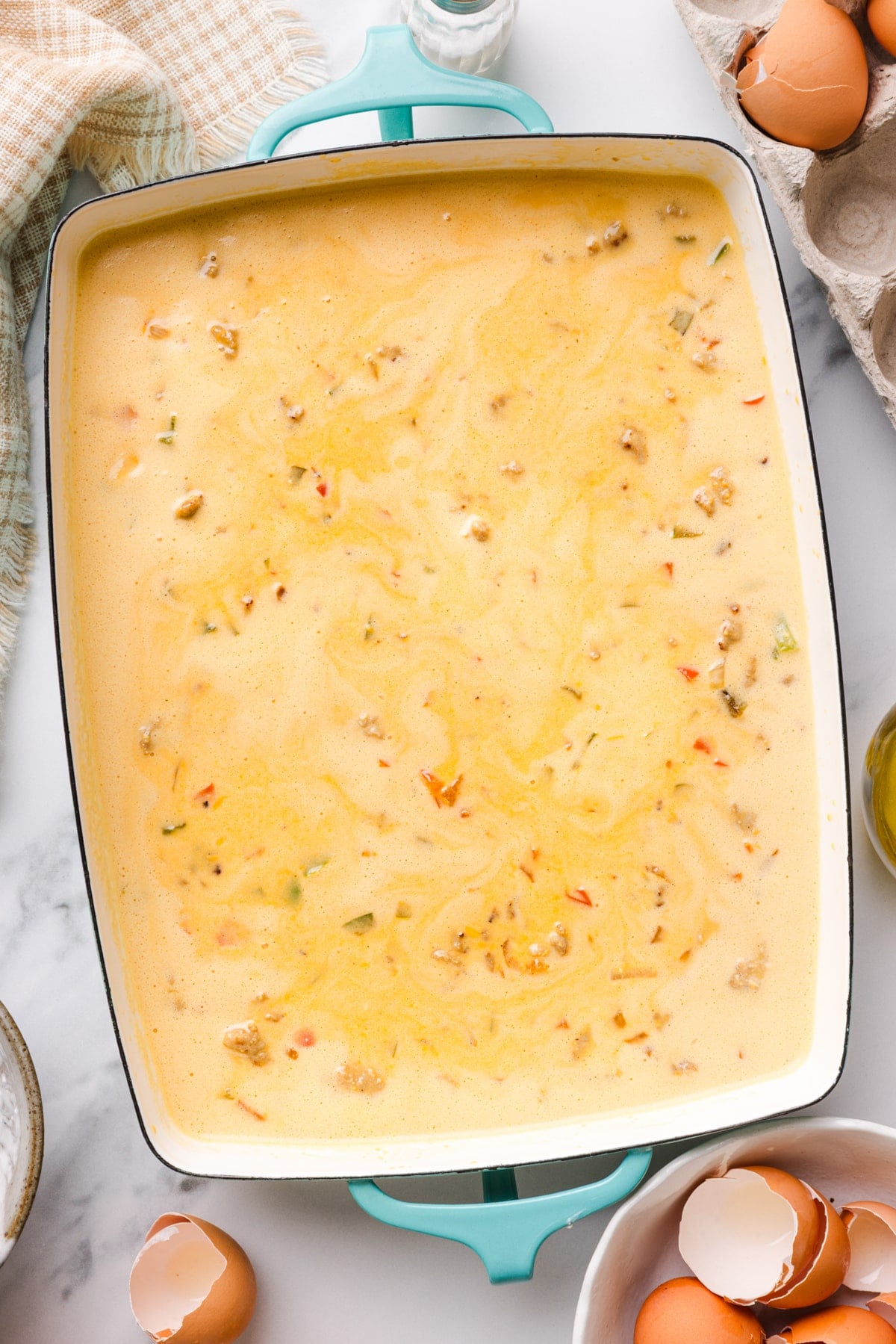 The egg bake mixture is in a rectangular baking pan before baking in the oven.