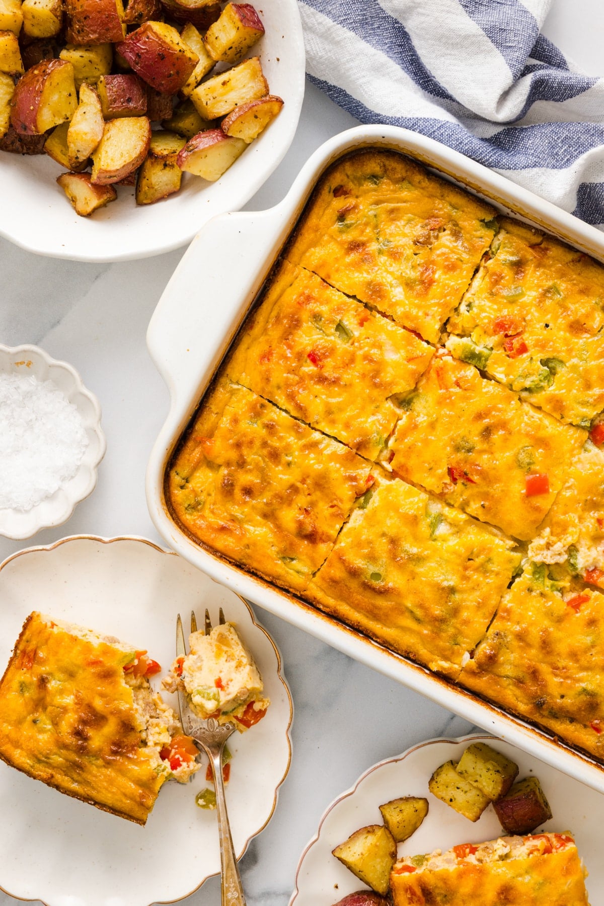 The cottage cheese egg bake sliced in the casserole dish on a white countertop for serving.