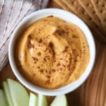 A close shot of pumpkin cottage cheese dip with green apple slices and graham crackers.