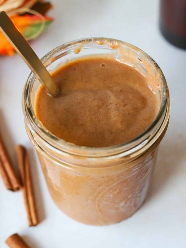 Pumpkin spice sauce in a mason jar with a spoon.